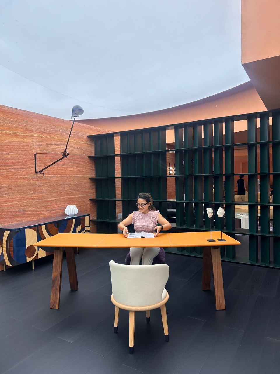 Melita reviewing design references at a desk